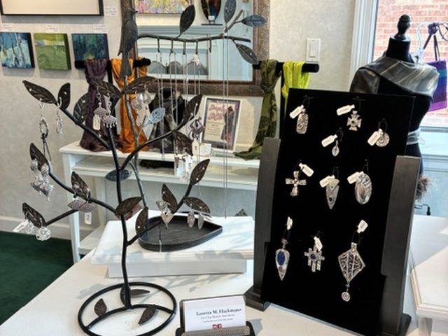 Sterling silver pendants and earrings on a metal jewelry tree and display board