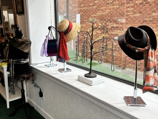 Scarves paired with hats along the front window sill