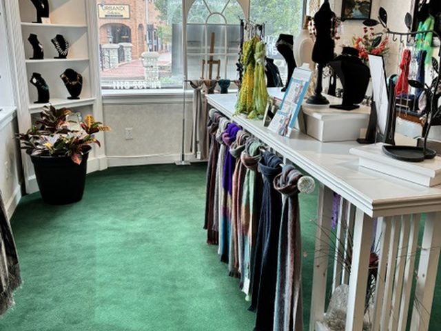 A long rack of scarves running the length of the display table